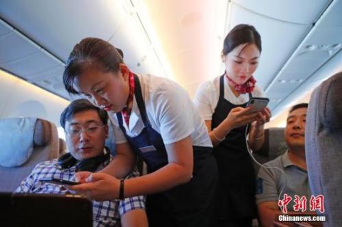 資料圖：乘務(wù)員們?cè)诳团搩?nèi)為旅客調(diào)試機(jī)上上網(wǎng)功能。<a target='_blank' ><p  align=